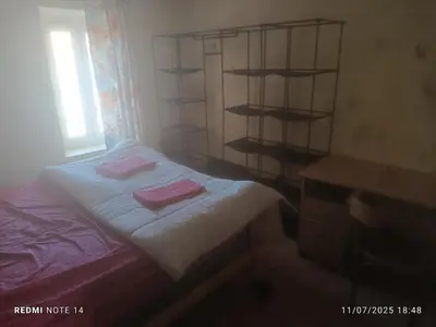 a bedroom with a bed with two pink towels on it at chambre double avec cuisine salon salle d'eau et cour avec barbecu en commun in Sigean