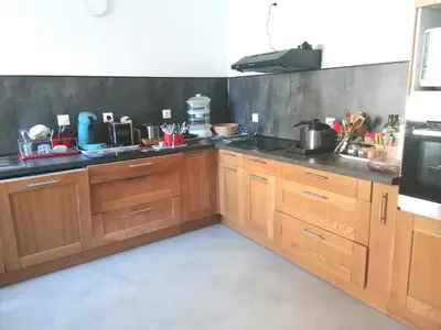 a kitchen with a microwave oven and a sink at chambre double avec cuisine salon salle d'eau et cour avec barbecu en commun in Sigean