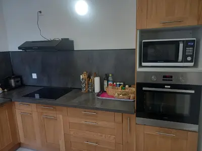 a kitchen with a sink and a counter top at chambre double avec cuisine salon salle d'eau et cour avec barbecu en commun in Sigean