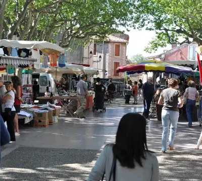 a group of people walking around an outdoor market at OCC34 - Capestang - Manoir in Capestang