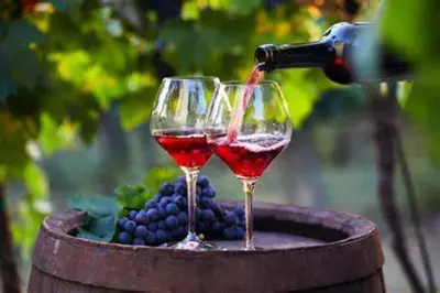 two wine glasses are being filled with red wine at OCC34 - Capestang - Manoir in Capestang