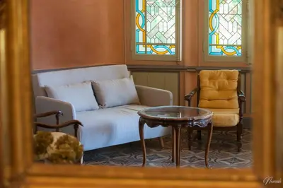 a living room with a couch and a table and stained glass windows at Gîte du parc à Langel in Armissan