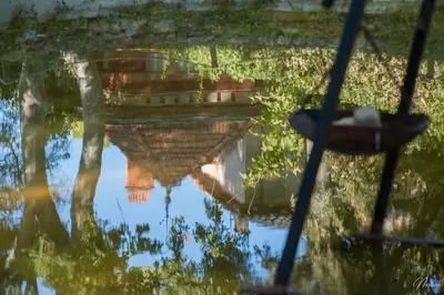 a reflection of a boat in a body of water at Gîte du parc à Langel in Armissan