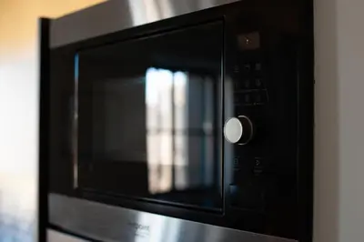 a microwave oven with its door open with a reflection at La maison rue Nadaud, au pied des remparts in Carcassonne