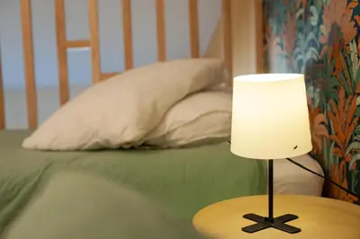 a lamp sitting on a table next to a bed at La maison rue Nadaud, au pied des remparts in Carcassonne