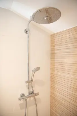 a shower in a bathroom with a light on the ceiling at La maison rue Nadaud, au pied des remparts in Carcassonne