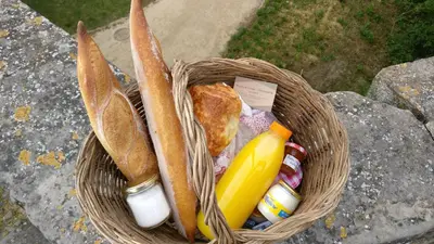 a wicker basket with a sandwich and a banana at La maison rue Nadaud, au pied des remparts in Carcassonne
