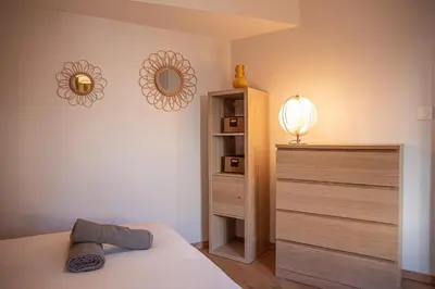 a bedroom with a bed and a dresser and a mirror at La maison rue Nadaud, au pied des remparts in Carcassonne