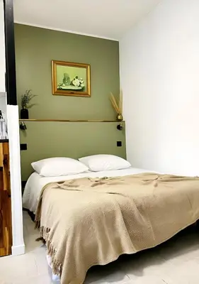 a bedroom with two beds and a green wall at Studio mosaïque Narbonne in Narbonne