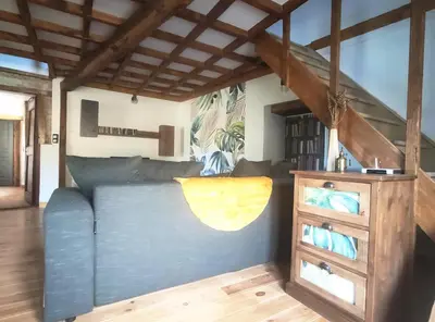 a living room with a blue couch and a dresser at Gîte du Fassac in Saint-Julien-du-Puy