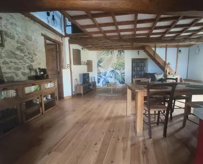 a living room with a wooden table and chairs at Gîte du Fassac in Saint-Julien-du-Puy