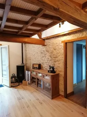 a room with a wooden table in a stone wall at Gîte du Fassac in Saint-Julien-du-Puy
