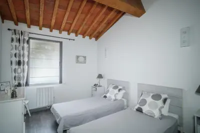 two beds in a white room with a window at Côté Grange à Bélesta in Bélesta