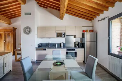 a kitchen with a table and chairs and a refrigerator at Côté Grange à Bélesta in Bélesta