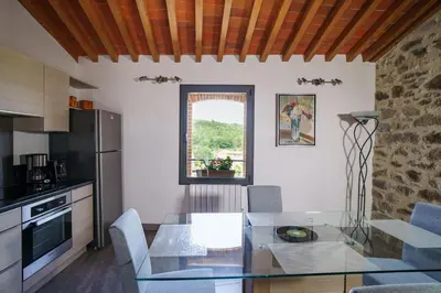 a kitchen with a glass table in a kitchen at Côté Grange à Bélesta in Bélesta