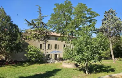 a large house with trees in front of it at Maison vigneronne de Bonne Maman - climatisée in Cesseras