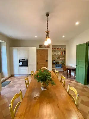 a dining room with a wooden table and chairs at Maison vigneronne de Bonne Maman - climatisée in Cesseras