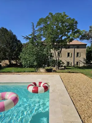 a swimming pool with two inflatables in front of a house at Maison vigneronne de Bonne Maman - climatisée in Cesseras