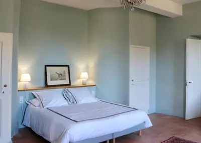 a bedroom with a bed with white sheets and two lamps at Maison vigneronne de Bonne Maman - climatisée in Cesseras