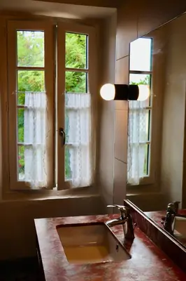a bathroom with a sink and a mirror and two windows at Maison vigneronne de Bonne Maman - climatisée in Cesseras