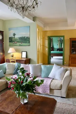 a living room with a couch and a vase with flowers at Maison vigneronne de Bonne Maman - climatisée in Cesseras