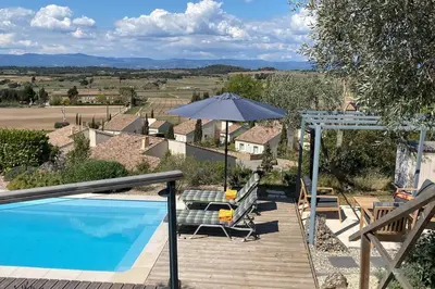 a house with a swimming pool and an umbrella at Neuve Romantique in Montbrun-des-Corbières