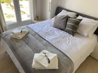 a large bed with two towels and pillows on it at Neuve Romantique in Montbrun-des-Corbières