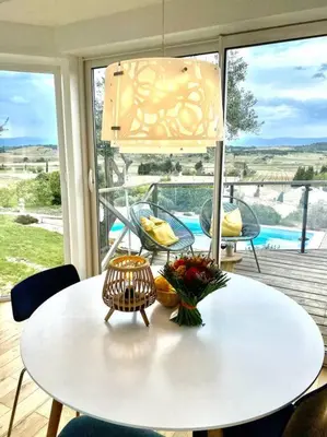 a white table with a vase of flowers on a porch at Neuve Romantique in Montbrun-des-Corbières
