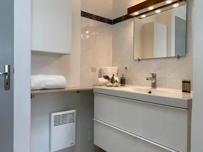 a white bathroom with a sink and a mirror at Neuve Romantique in Montbrun-des-Corbières