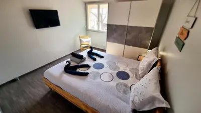 a bedroom with a bed with pillows and a television at Villa d'Architecte - Cocon Design, Calme & Mer in Fitou