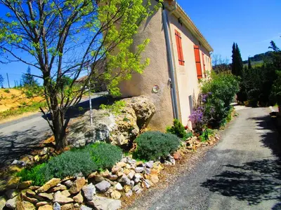 a house with a rock garden next to a street at Maison champêtre à Tournissan avec grand jardin in Tournissan