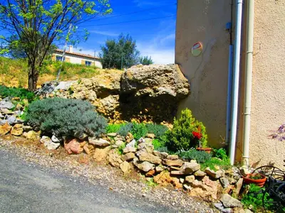 a garden of rocks and plants next to a building at Maison champêtre à Tournissan avec grand jardin in Tournissan