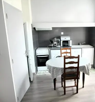 a small kitchen with a table and two chairs at Maison champêtre à Tournissan avec grand jardin in Tournissan