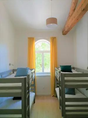 a room with three bunk beds and a window at Gîte de l'Abbé 8 à 10 personnes in Lempaut