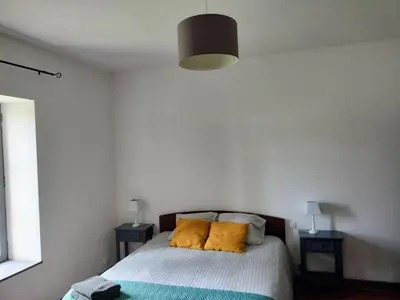 a bedroom with a bed with yellow pillows on it at Maison de Pierre 4 à 6 personnes in Lempaut