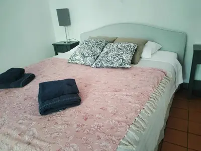 a bed with pillows and a pink blanket on it at Maison de Pierre 4 à 6 personnes in Lempaut