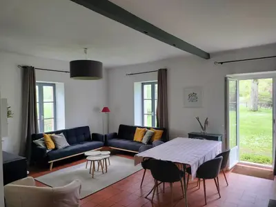 a living room with a couch and a table at Maison de Pierre 4 à 6 personnes in Lempaut
