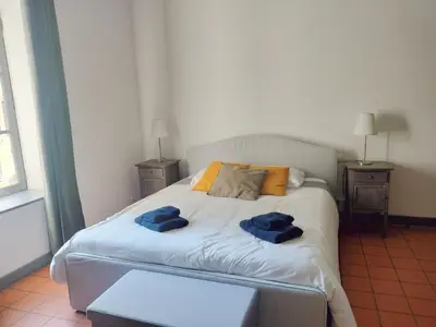 a bedroom with a bed with two blue towels on it at Maison de Pierre 4 à 6 personnes in Lempaut