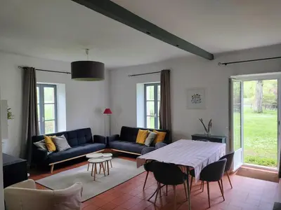 a living room with a blue couch and a table at Maison de Pierre 4 à 6 personnes in Lempaut