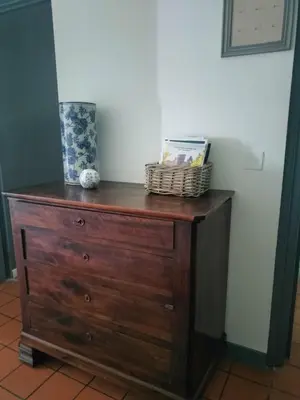 a wooden dresser with a basket on top of it at Maison de Pierre 4 à 6 personnes in Lempaut
