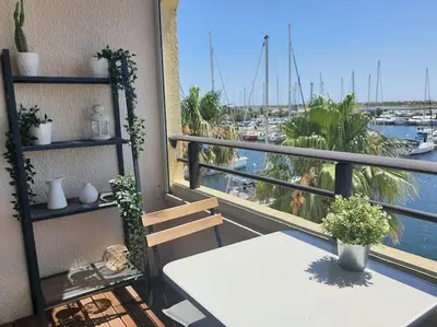 a balcony with a table and a view of a harbor at Au bord de l'eau, Profitez d'un moment de calme ! in Gruissan