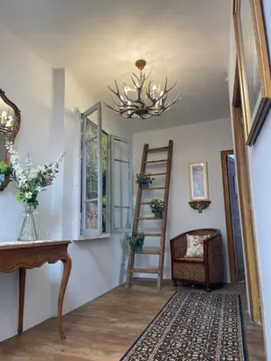 a hallway with a staircase and a chandelier at The French House in Quillan in Quillan