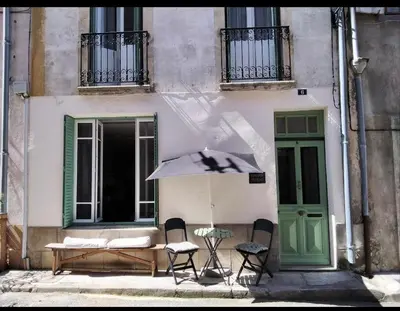 a building with a table and chairs and an umbrella at The French House in Quillan in Quillan