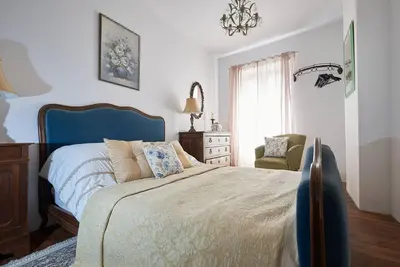 a bedroom with a large bed and a chair at The French House in Quillan in Quillan