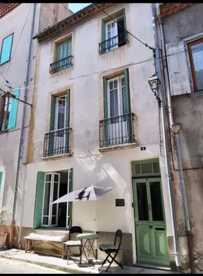 a table with an umbrella in front of a building at The French House in Quillan in Quillan