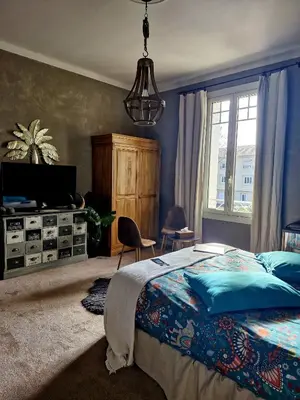 a bedroom with a bed and a chandelier at Villa Maskali in Cuxac-dʼAude