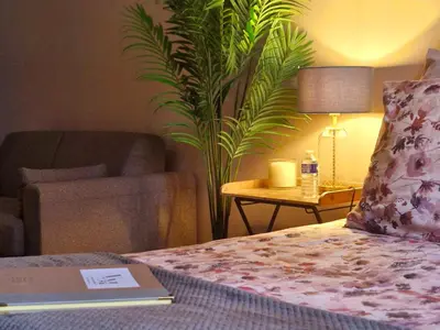 a bedroom with a bed with a lamp and a couch at Villa Maskali in Cuxac-dʼAude