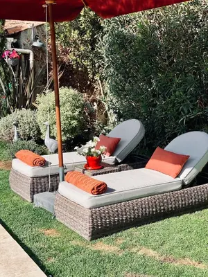 two wicker chairs and an umbrella in a yard at Villa Maskali in Cuxac-dʼAude