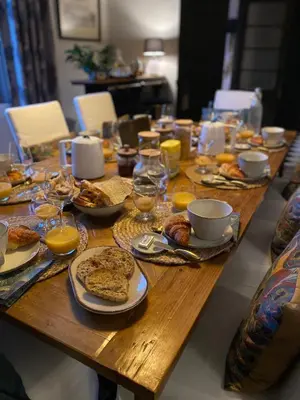 a wooden table topped with plates of food and drinks at Villa Maskali in Cuxac-dʼAude