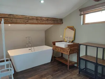 a bathroom with a white tub and a sink at La Terrasse du Temps Jadis in Carcassonne